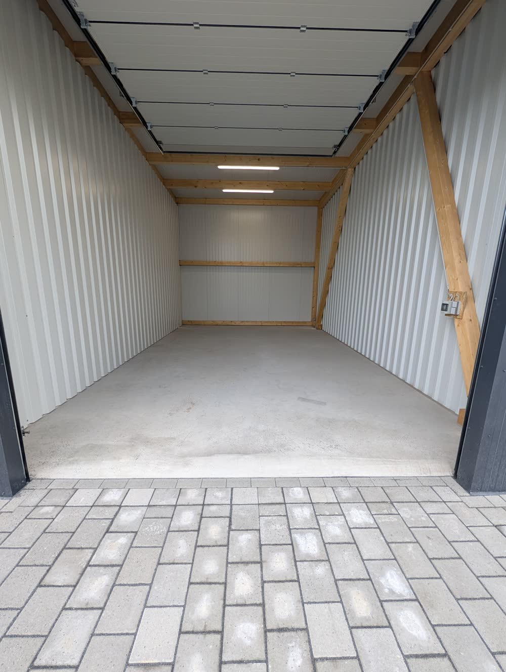Innenausbau einer Einheit mit heller Verkleidung, Holzbalken und LED-Beleuchtung